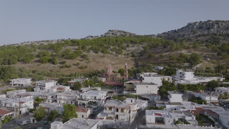 Antena-Sobre-El-Pueblo-De-Pilonas-En-Rodas,-Grecia---Vista-De-La-Iglesia-Ortodoxa-Griega