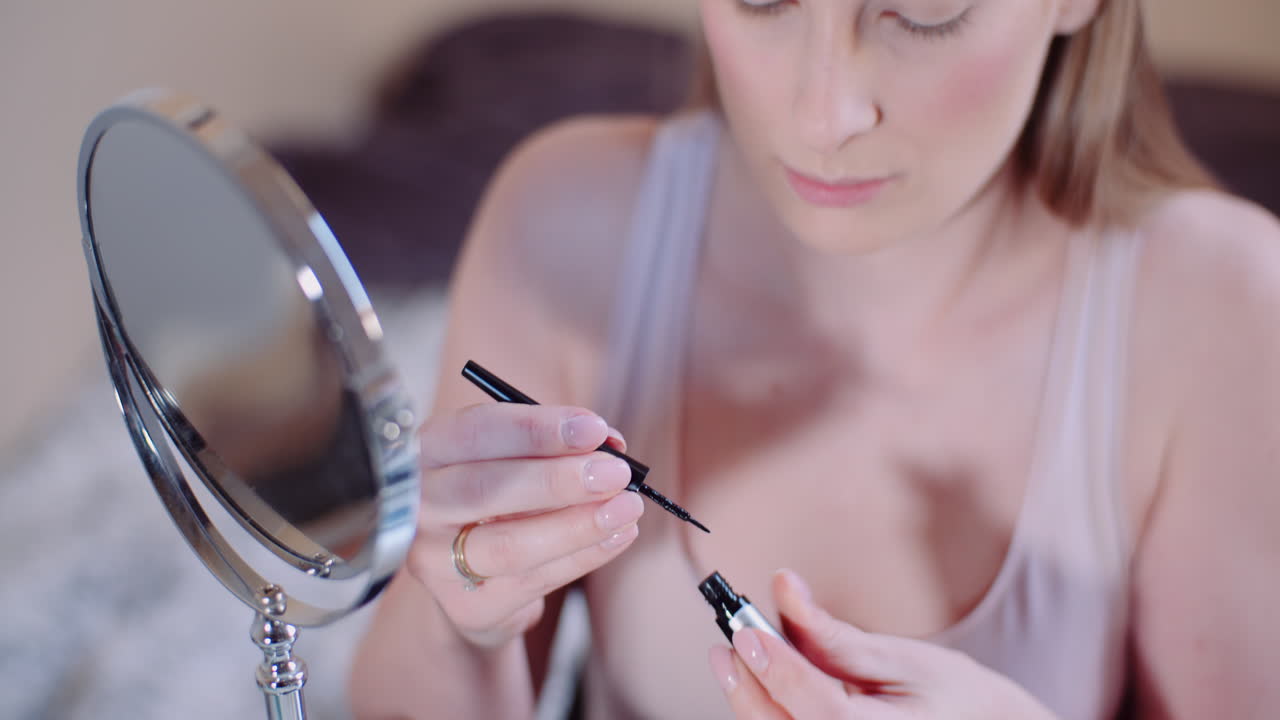 mujer maquillándose pintando pestañas con rímel 5