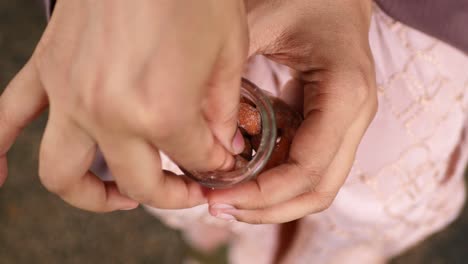 hand holding a glass jar of sugared cashews