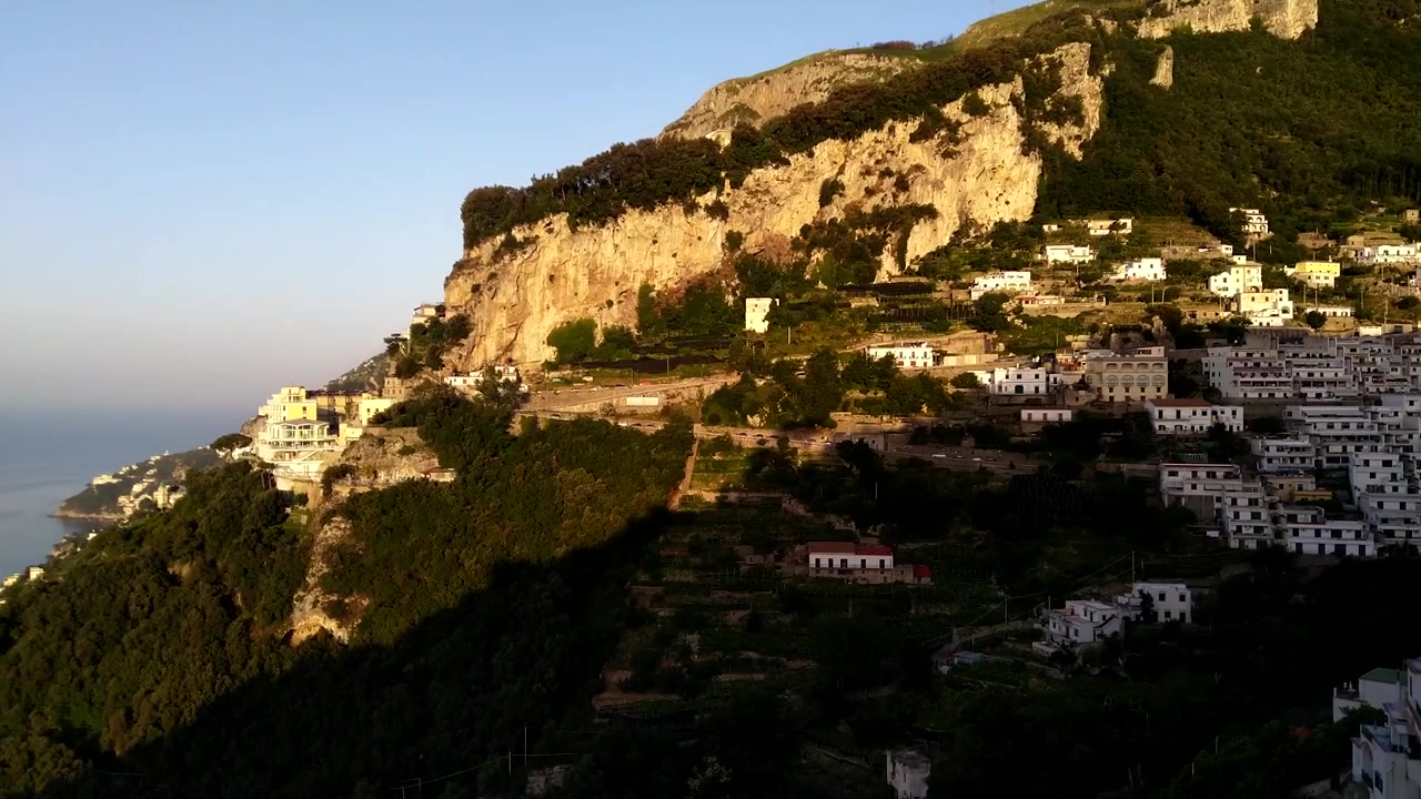 Panoramica dall'alto della città di Amalfi, Italia, con una vista mozzafiato di montagne, scogliere e un bellissimo oceano