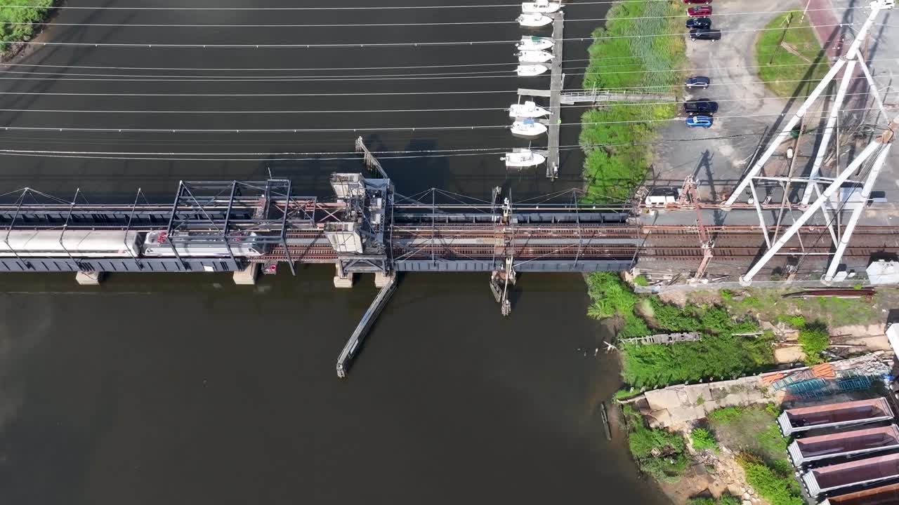 vista aérea de un tren que pasa por un puente sobre el arroyo cheesequake en morgan, nj