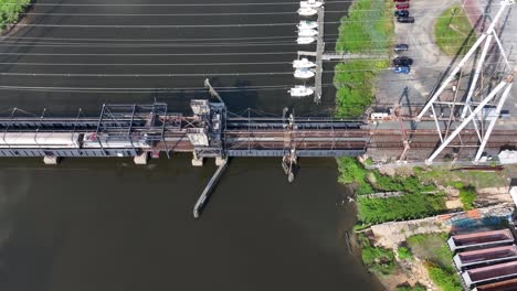 Aerial-View-of-a-Train-Passing-by-on-a-Bridge-over-Cheesequake-Creek-in-Morgan,-NJ