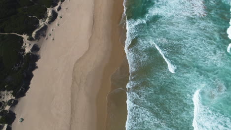 Antena:-Olas-Suaves-Que-Corren-Hacia-Una-Playa-Prístina,-Toma-Ascendente-De-Arriba-Hacia-Abajo