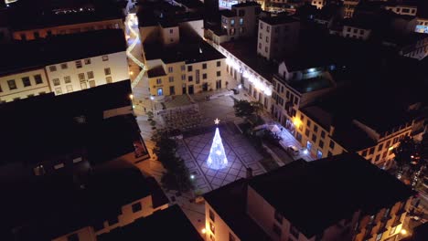 Plaza-Idílica-Con-árbol-De-Navidad-Resplandeciente-Con-Estrella-En-La-Ciudad-De-Madeira-Por-La-Noche,-Antena