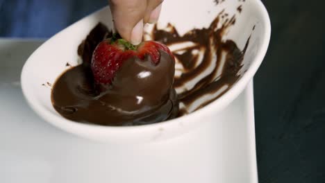 fresh healthy strawberry being dipped in melted chocolate vegan valentines day dessert