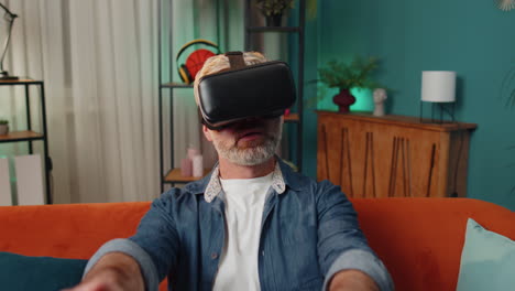 Man-using-virtual-reality-futuristic-technology-headset-to-play-simulation-3D-video-game-at-home