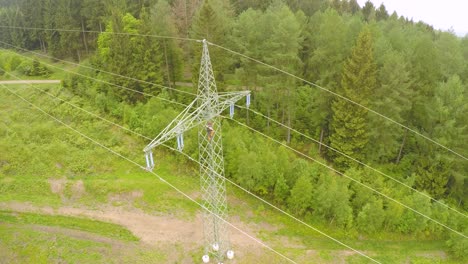 electrician working on high voltage power line tower in the forest