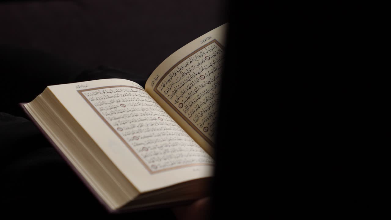 una toma ligeramente en movimiento que muestra a un lector del corán en un entorno pacífico