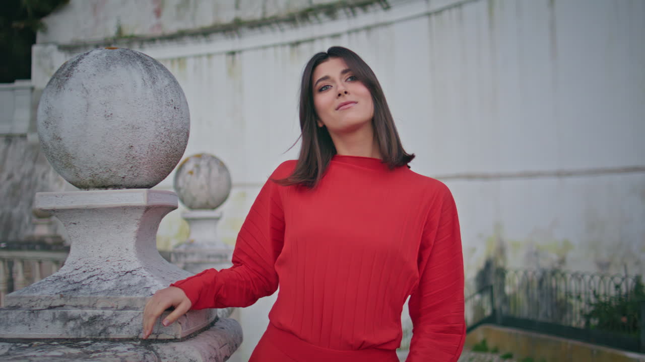 Gorgeous woman strolling city landmark at evening closeup. Model looking camera