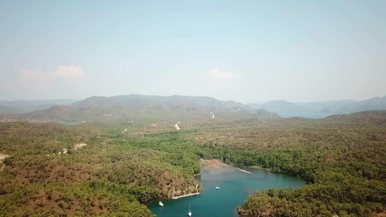Aerial view of the river with anchored boats in Turkey, mountains and sky behind