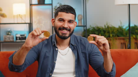 indio independiente hombre comerciante de acciones con dos bitcoins de oro btc desarrollador exitoso programador