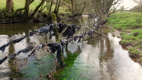 plastic pollution on a river in cumbria from farming practices such as big baling silage which involves wrapping it in large amounts of black plastic which seems to find it's way into the river system