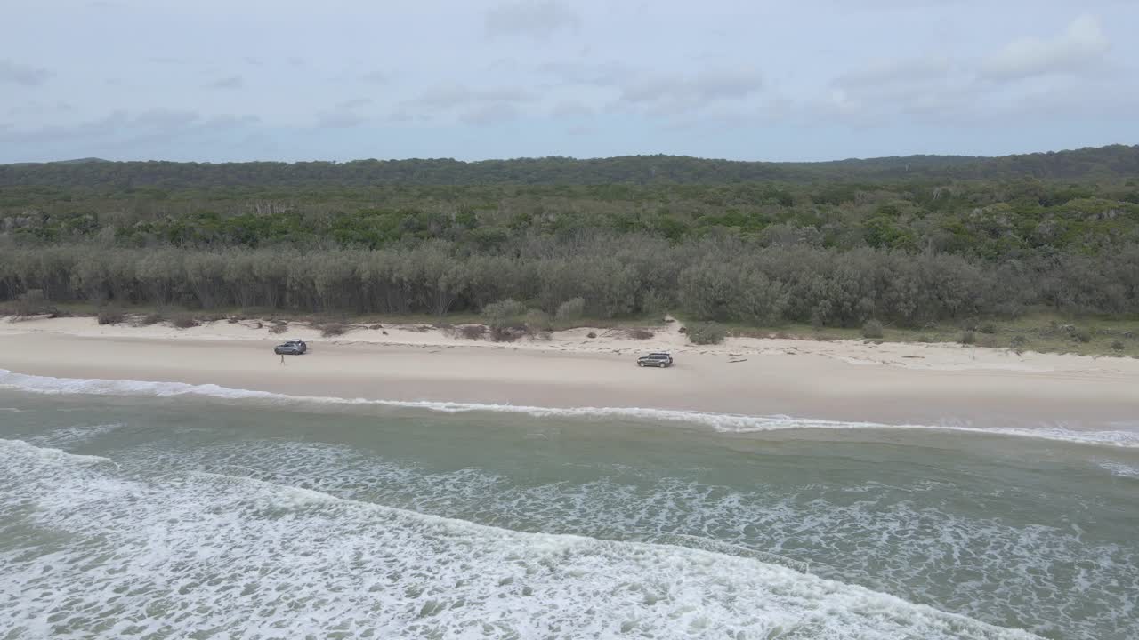 vuela en los vehículos que viajan en la costa arenosa de north stradbroke island en moreton bay, queensland, australia