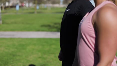 Cropped-shot-of-young-people-training-with-dumbbells-in-park.