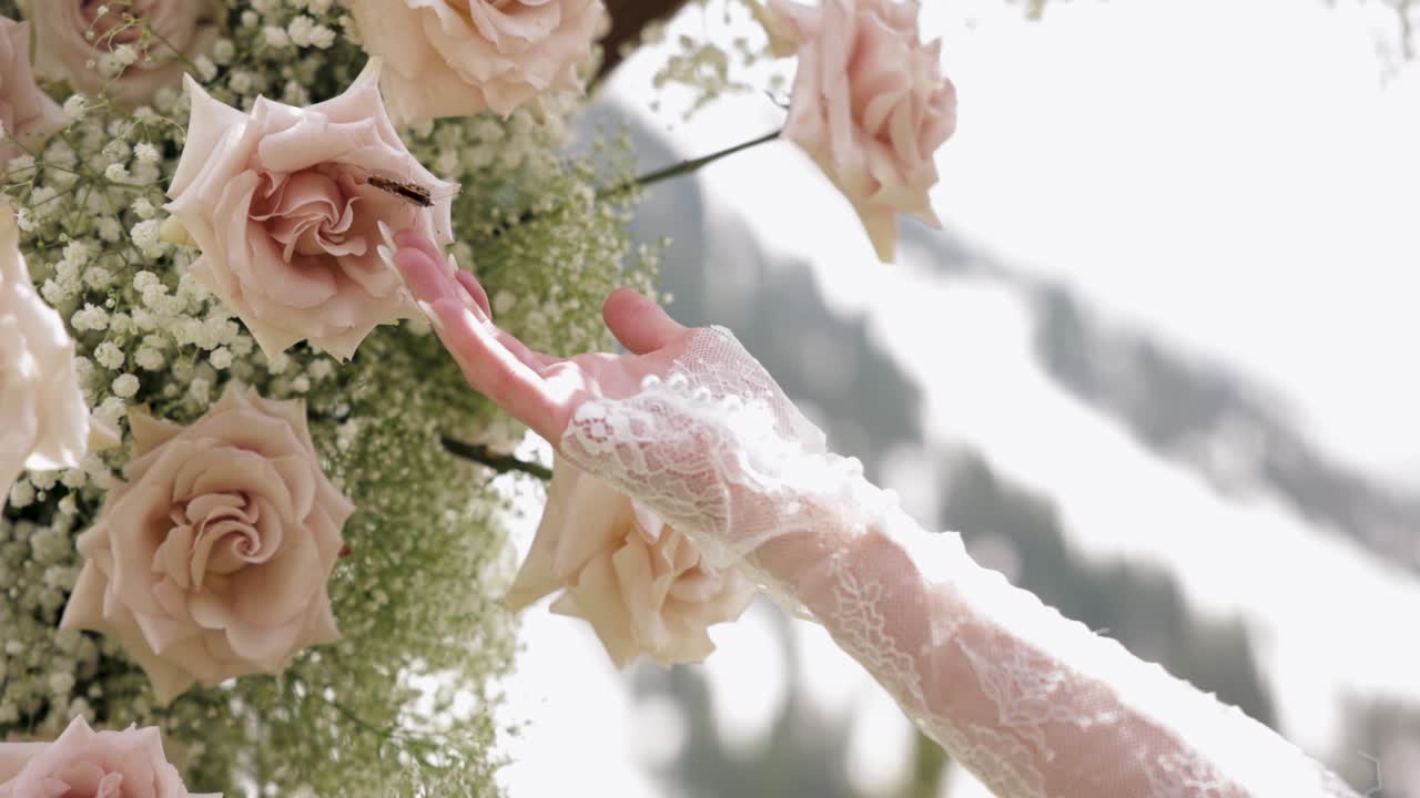 Bride's Hand Reaches for Butterfly Sitting on Wedding Flowers and Butterfly Flies Away