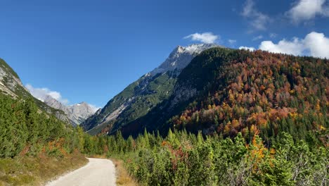 Wunderschöne-Herbstlandschaft-In-Der-Nähe-Von-Scharnitz-In-Österreich-Mit-Bunten-Laubbäumen-Und-Schneebedeckten-Bergen-Im-Hintergrund,-Schwenkpanoramaaufnahme