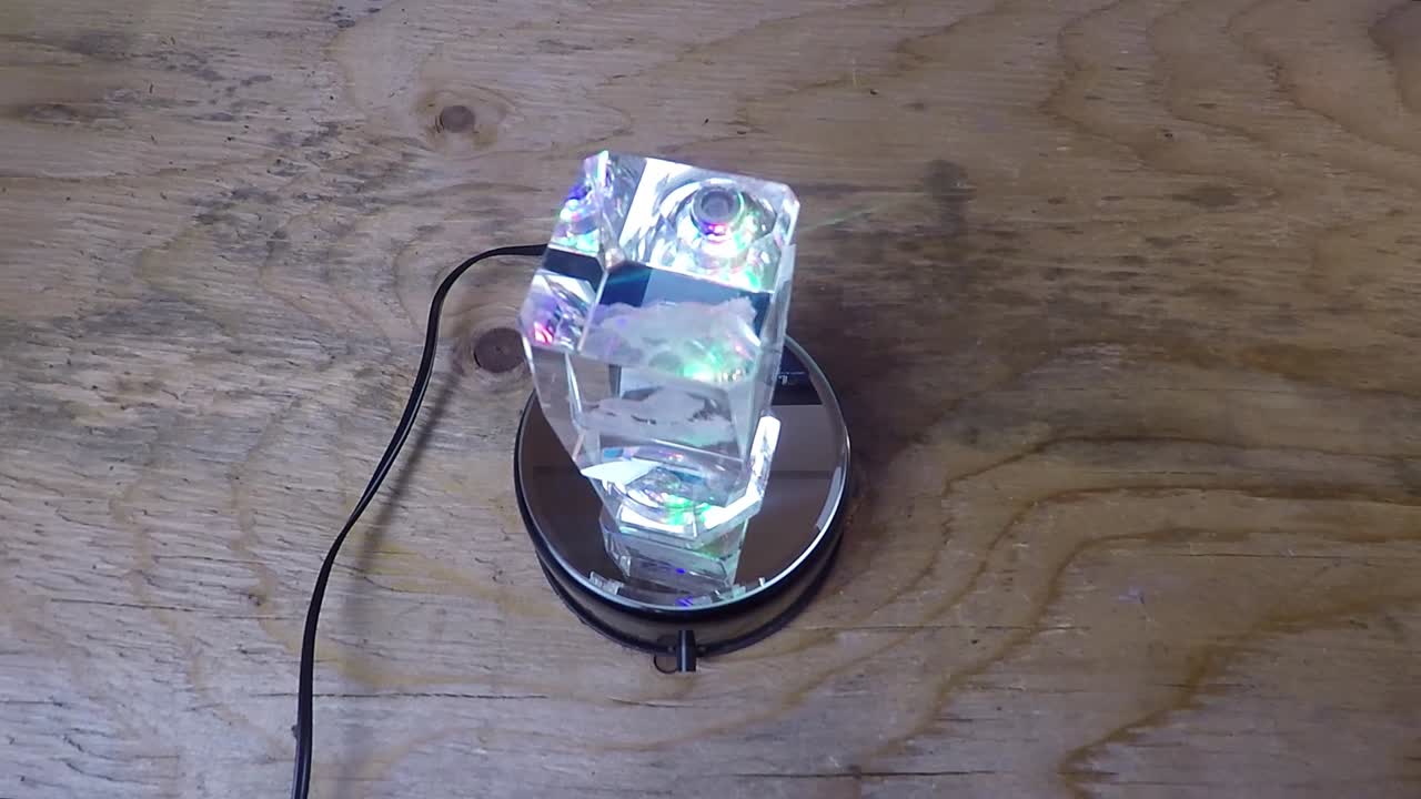Crystal art of a loin rotating on a wooden table.