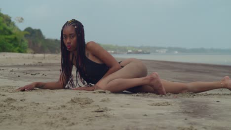 a young girl in a bikini having fun on a caribbean beach lay in the sand