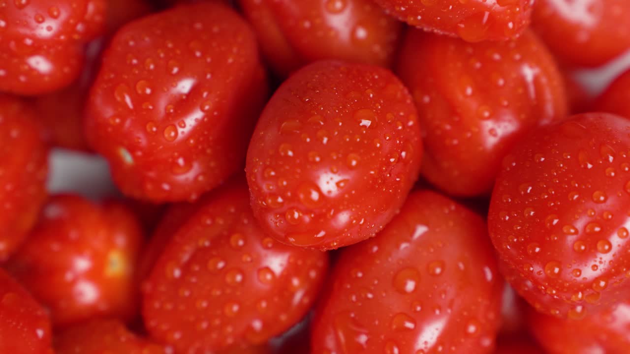 Detaillierte Makroaufnahme von frischen Kirschtomaten mit Wassertropfen, die Textur und Frische hervorheben. Konzept für Bio-Lebensmittel, gesunde Ernährung, natürliche Zutaten und Hofprodukte