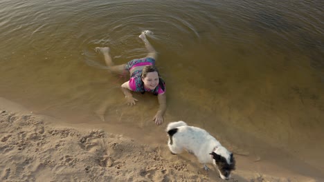 young girl dog beach playing ocean lake water fun