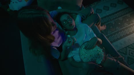 two girls watching movie at home