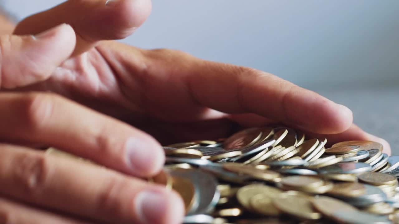 Large number of coins. Hand that holds the money.