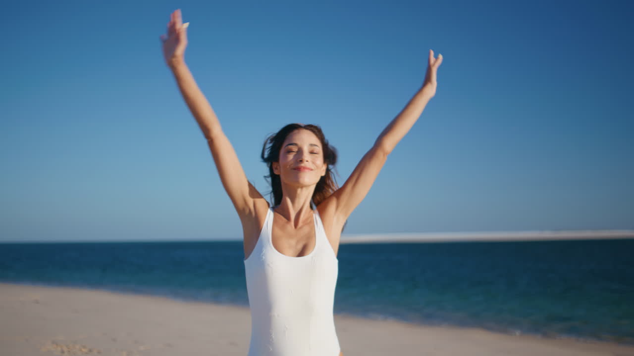 Serene girl spinning ocean shore enjoying carefree summer weekend. Happy woman