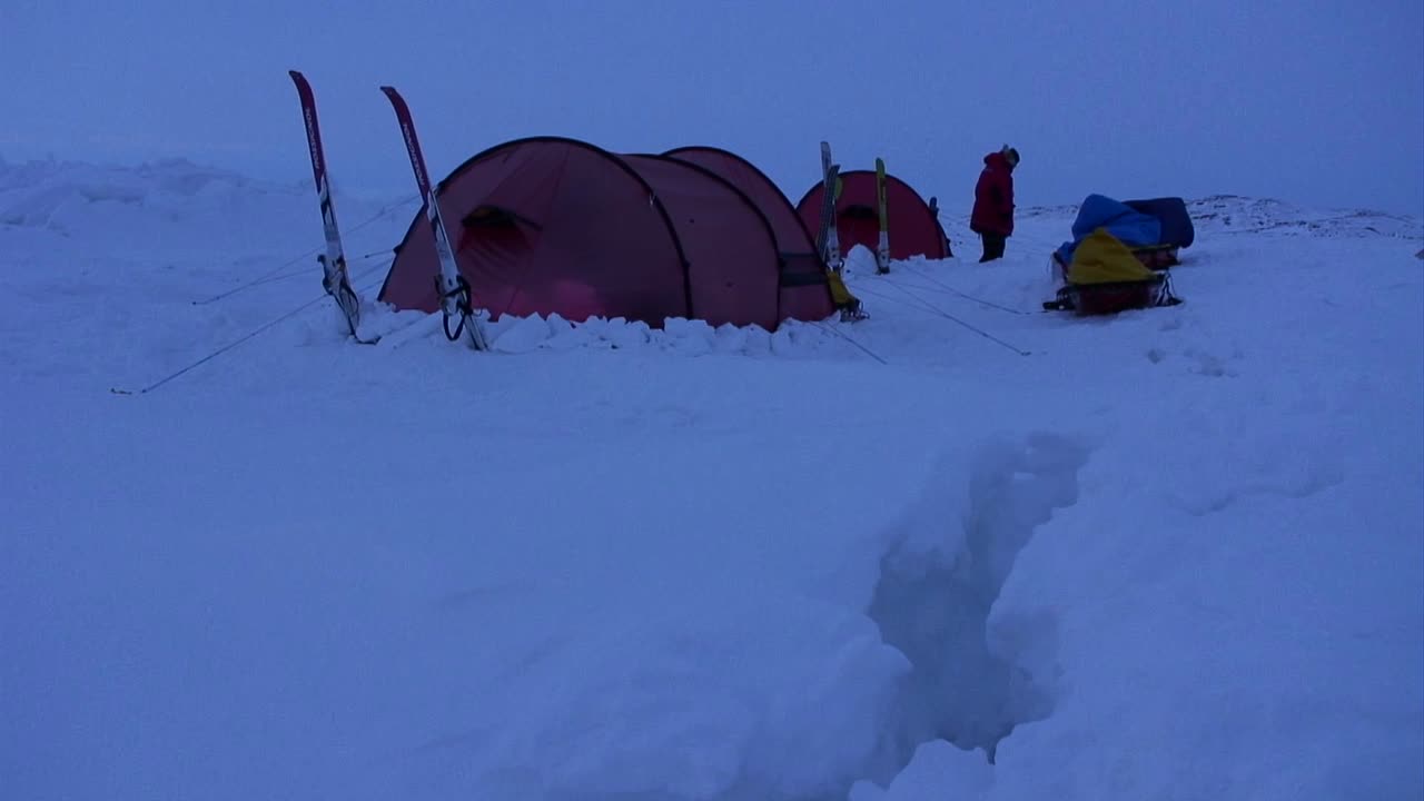 밤에 북극 탐험에서 깊은 눈 속에서 야영하는 사람들