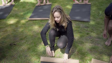 People rolling yoga mats in park