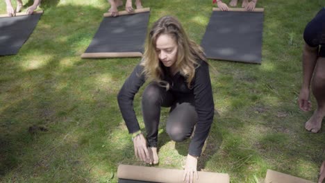 people rolling yoga mats in park