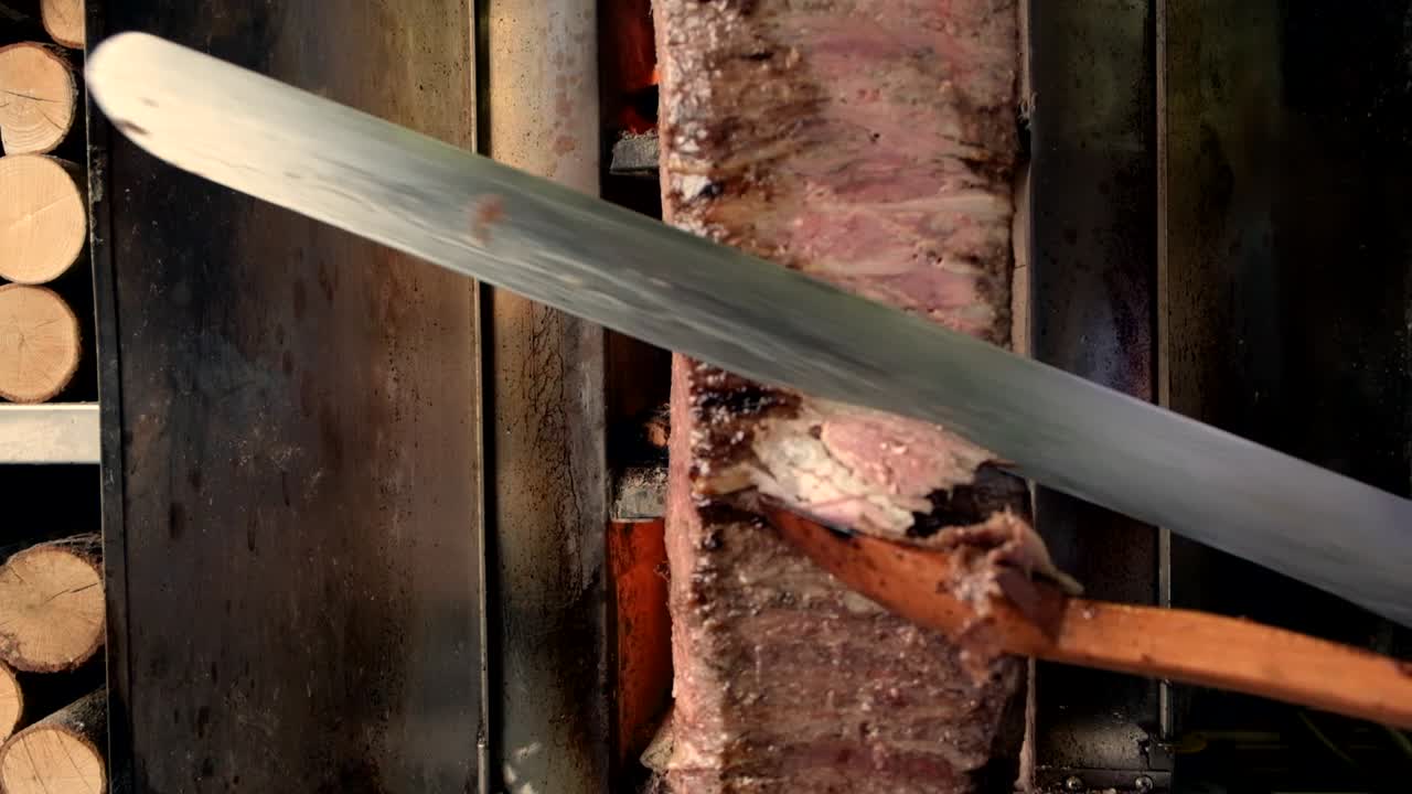 The chef slices the pieces of meat shawarma