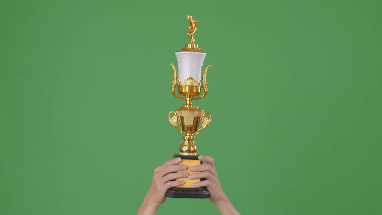 las manos levantadas de un hombre están sosteniendo un trofeo. fondo de pantalla verde