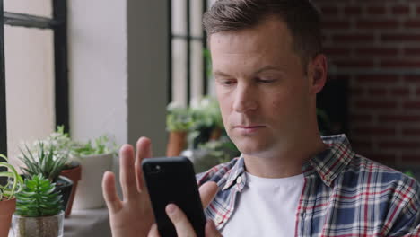 portrait-attractive-caucasian-man-using-smartphone-at-home-enjoying-relaxed-morning-browsing-messages-texting-social-media-networking-online