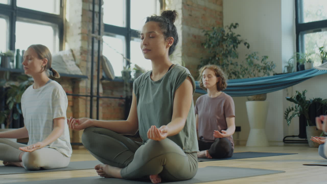 Woman Meditating during Group Yoga Class