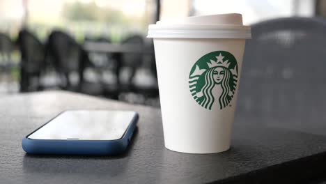 starbucks coffee cup and mobile phone on a table