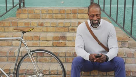 Afroamerikanischer-Mann,-Der-Sein-Telefon-Auf-Der-Straße-Benutzt