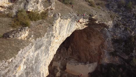 equipo de rescate colgando de cuerdas sobre una cueva enorme