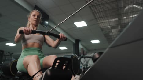 Low-angle-of-caucasian-woman-exercising-on-rowing-machine.