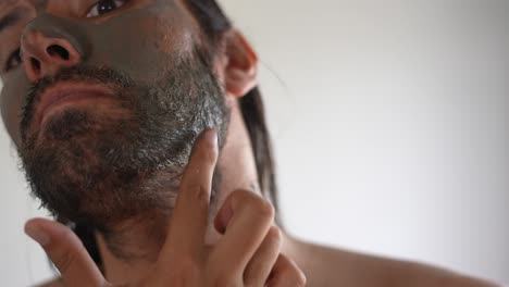 man using a clay mask on his face, facial