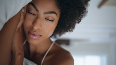 serene woman sleeping pillow hotel closeup. african girl opening eyes at morning