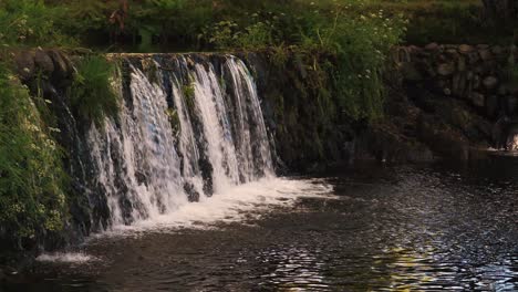 una cascada que desemboca en un pequeño arroyo