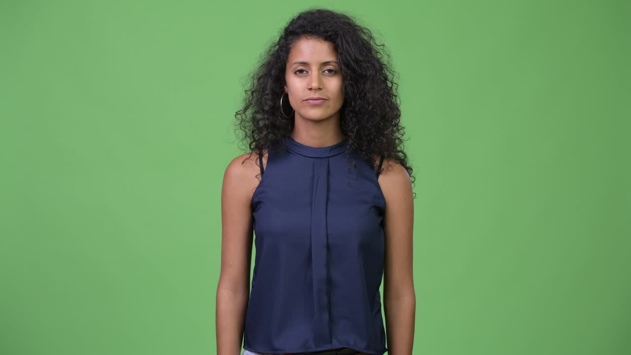 Giovane e bella donna d'affari ispanica con un dito sulle labbra