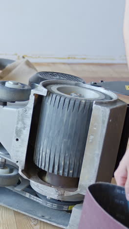 replacing sanding paper roll of industrial machine, vertical view