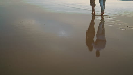 lovers feet walking sand beach vacation. uncnown couple stepping shore vertical