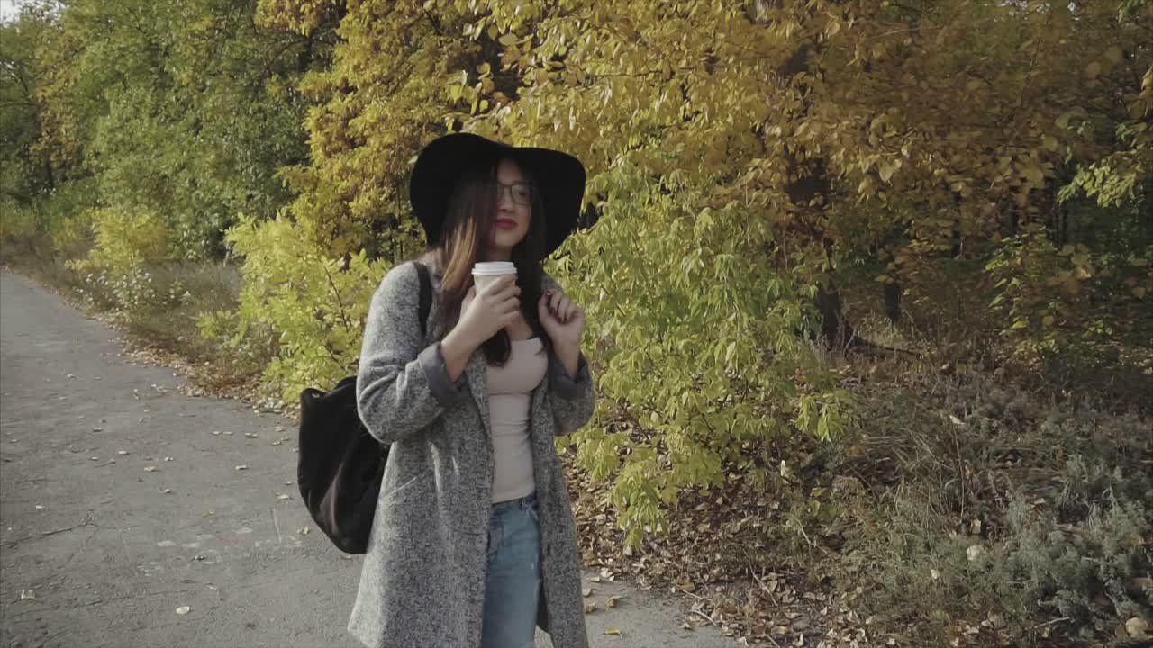 Kvinne nyter kaffe i høstpark
