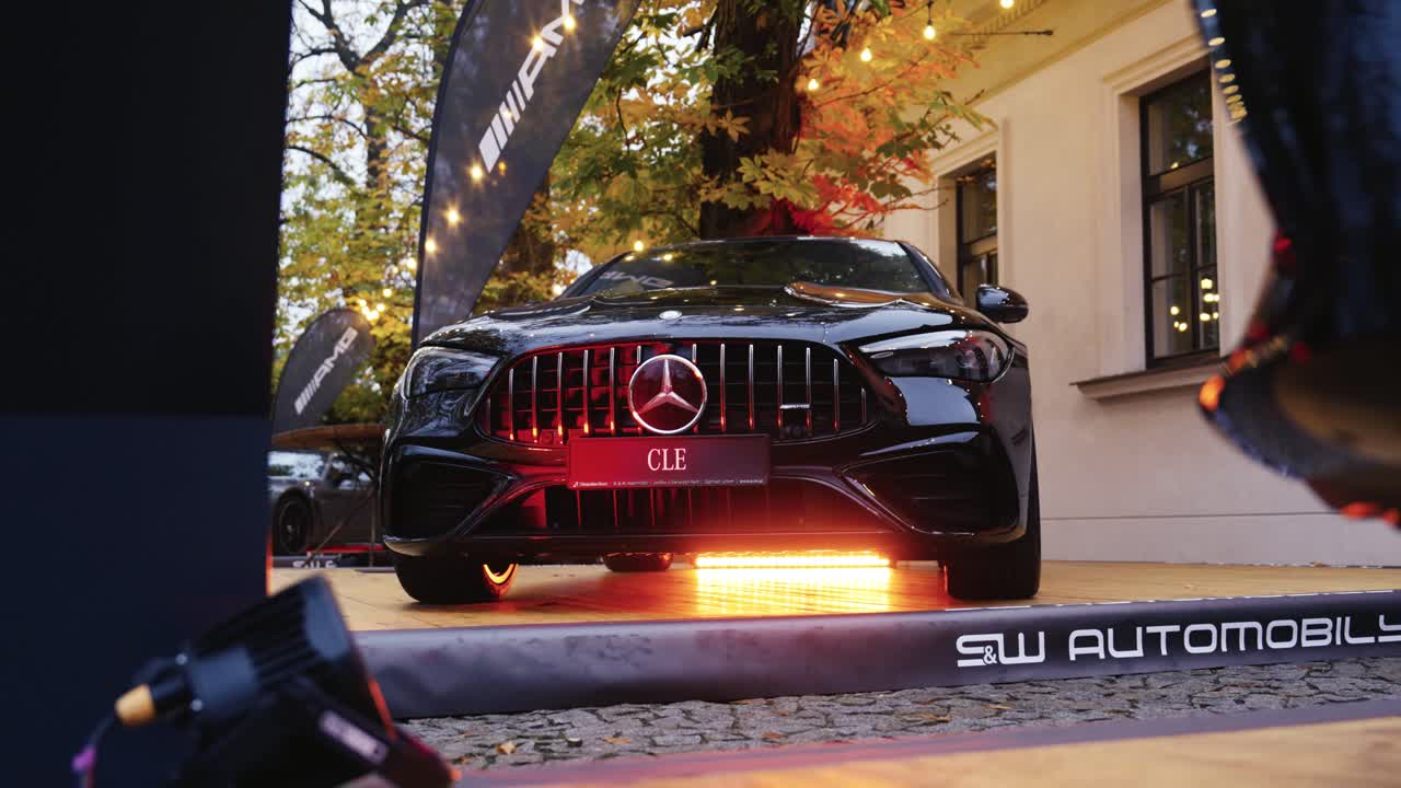 Black car with large logo on radiator grill parked near building, Czechia
