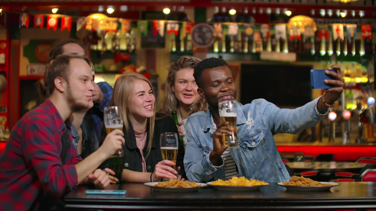 In un bar o ristorante, una donna ispanica si fa un selfie con le sue migliori amiche. Gruppo di giovani belli in un locale elegante