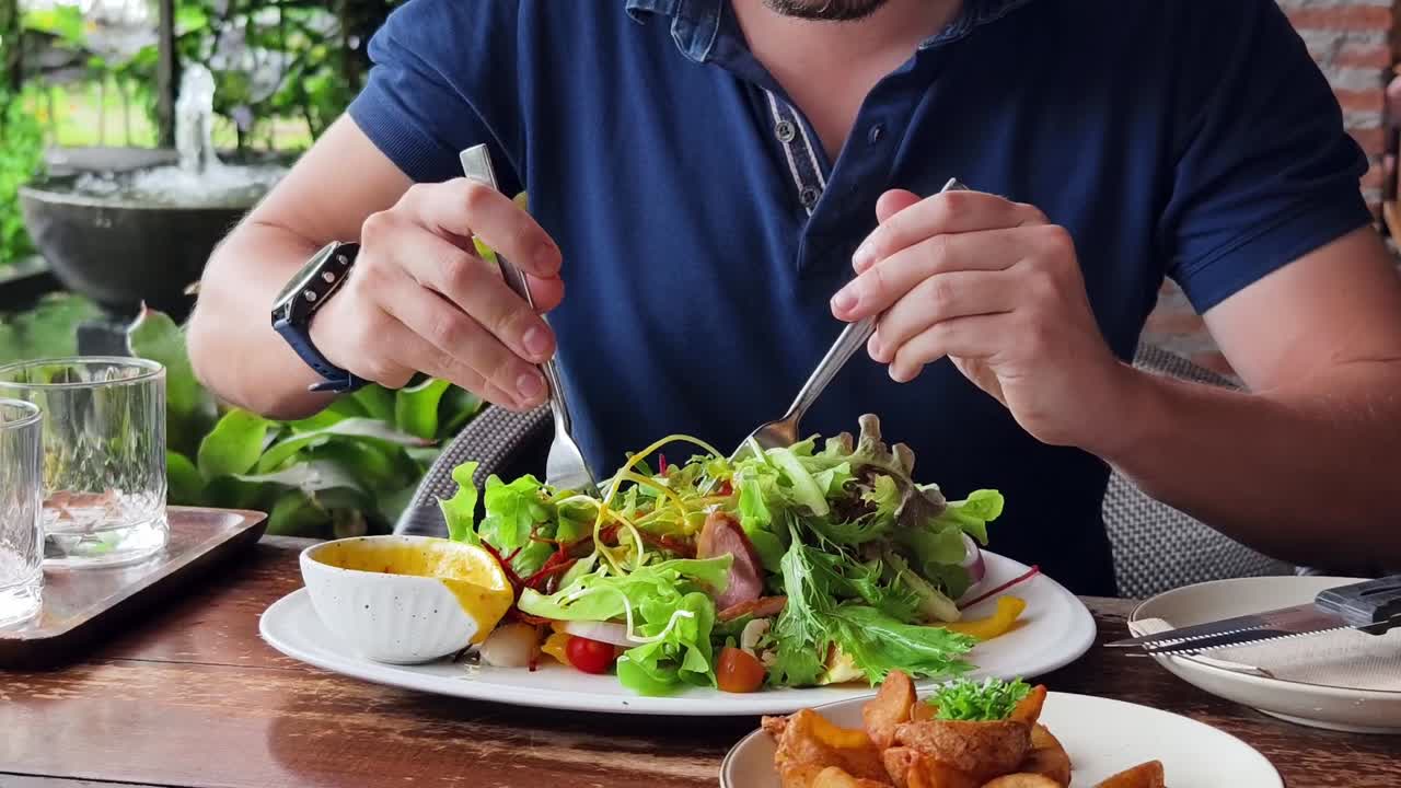 hombre comiendo ensalada en un café