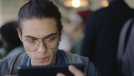 Atractivo-Joven-Caucásico-Usando-Una-Tableta-Digital-En-Una-Cafetería-Bebiendo-Café-Estudiante-Disfrutando-Viendo-Entretenimiento-En-Línea-Leyendo-Redes-Sociales-En-Un-Dispositivo-Portátil-Usando-Gafas