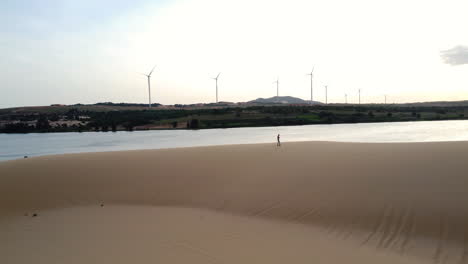 Man-walking-alone-during-sunset-in-white-sand-dunes-of-Vietnam